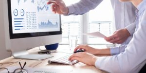 Pessoas avaliando gráficos em um sistema.