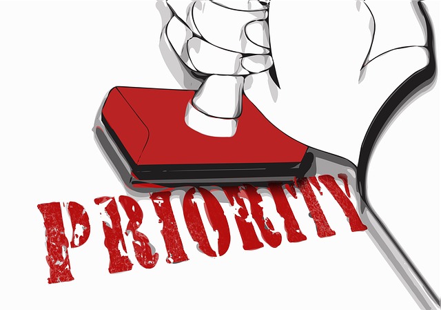 Ilustração de mão carimbando a palavra: "Priority". Priorizar chamados de TI.