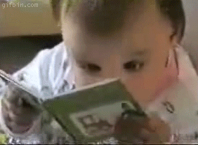 Gif de bebê olhando rapidamente um pequeno livro em suas mãos.