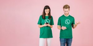 alt=homem-serio-e-mulher-usando-telefone-celular-no-pano-de-fundo-rosa