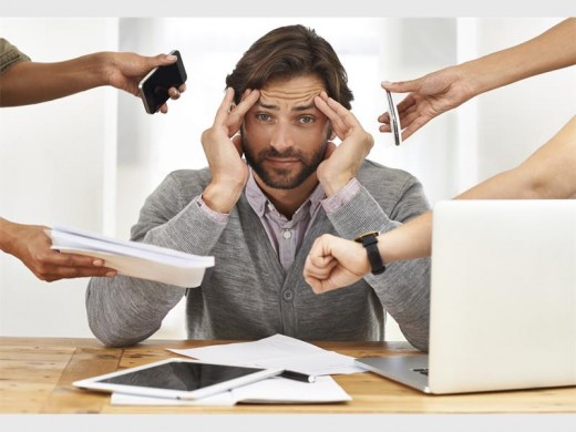Homem rodeado por várias mãos mostrando celular, papéis, relógio. Guia prático de técnicas para lidar com o estresse no atendimento ao cliente.