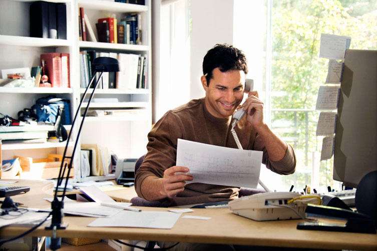 Foto homem ao telefone no seu Home Office.