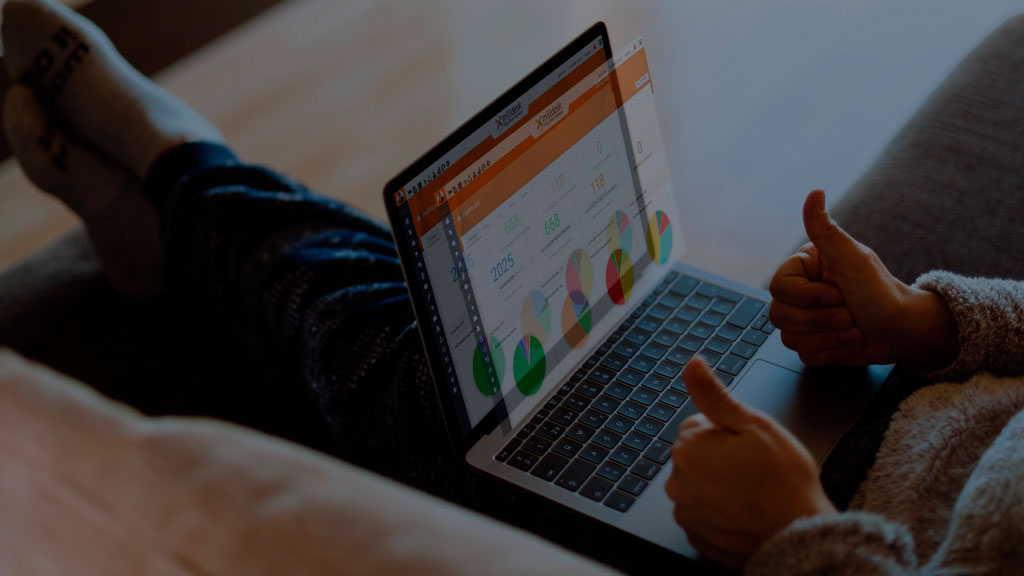 Pessoa com notebook ao colo fazendo sinal de positivo para a dashboard do Milldesk.