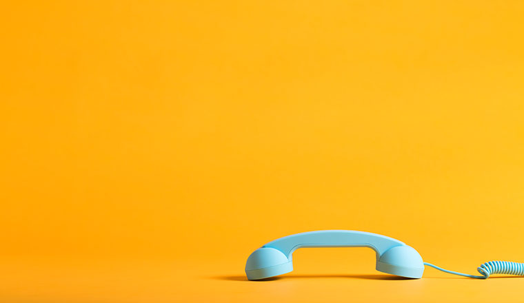 Imagem de telefone branco em fundo amarelo, aumentar a satisfação dos clientes em tempos de crise.