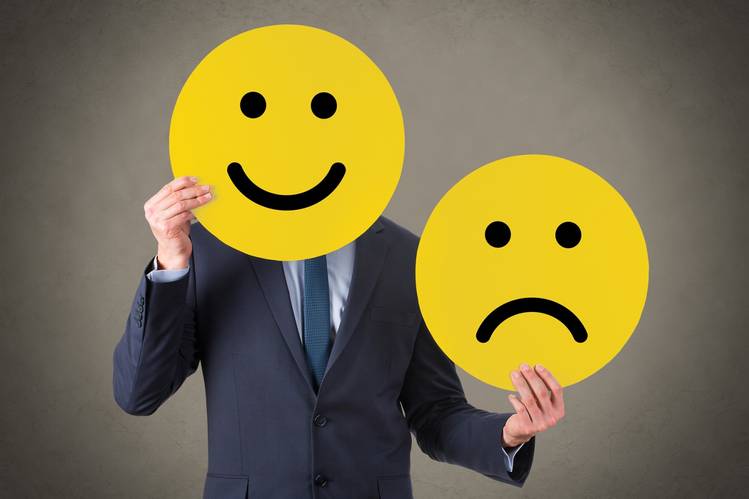 Imagem homem com smiley sorridente no rosto e triste na mão esquerda. Aumentar a satisfação dos clientes em tempos de crise