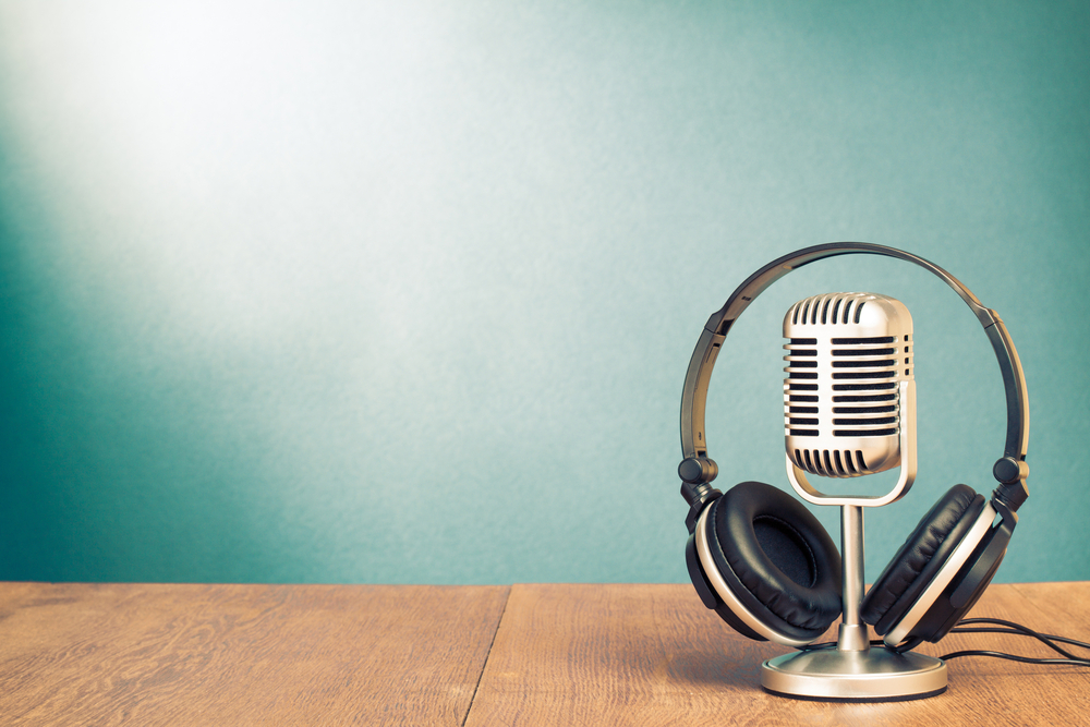 Headphone em cima de microfone vintage. Podcasts sobre atendimento ao cliente e tecnologia.